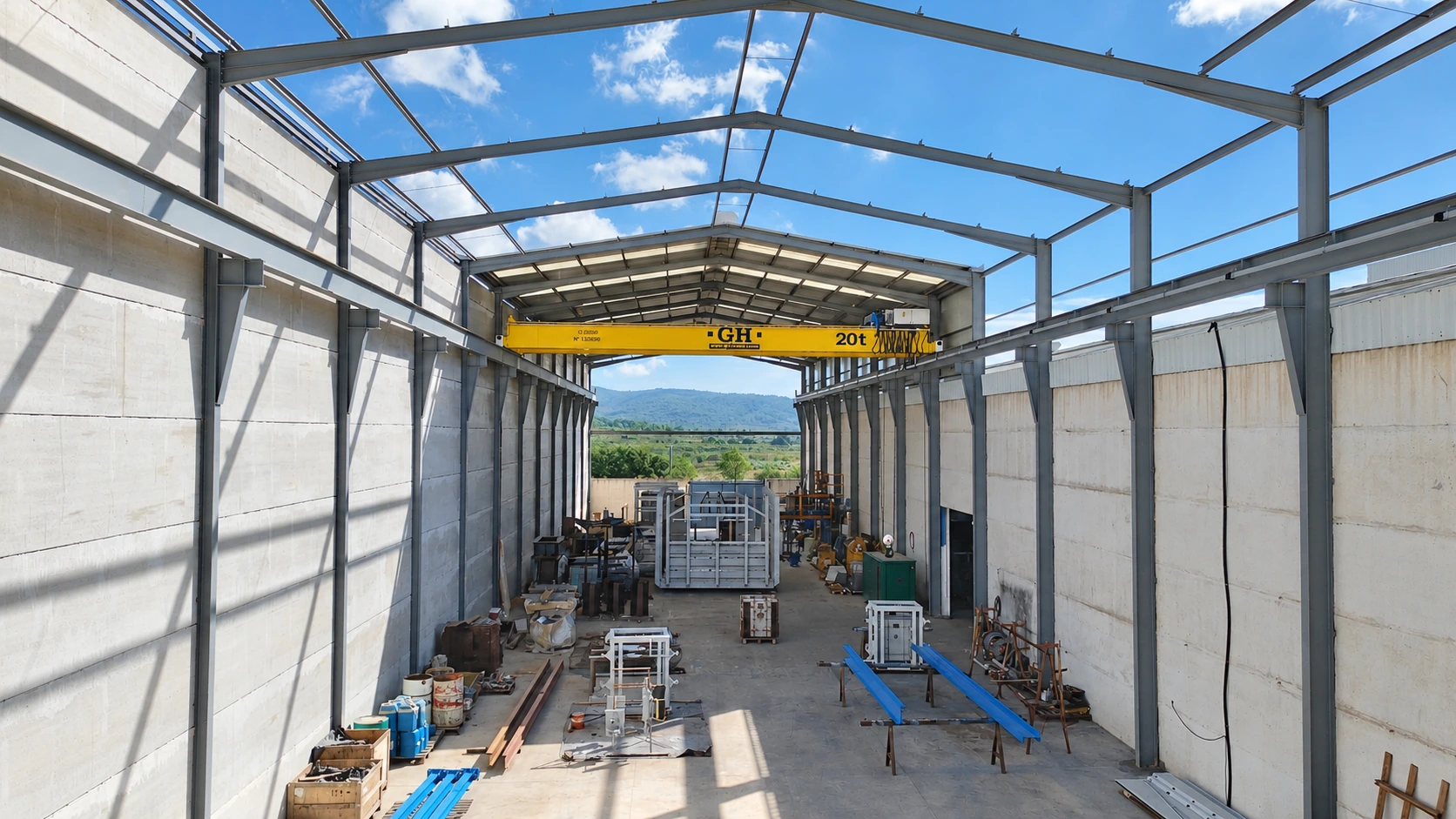 Vista de la nave del taller con la estructura de cubierta abierta y el puente grúa amarillo